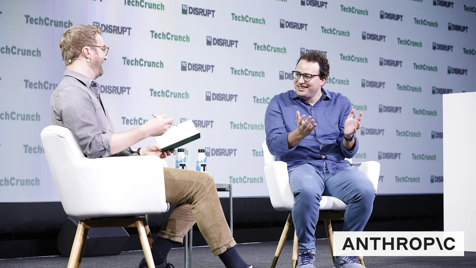 Anthropic CEO Dario Amodei on stage at TechCrunch Disrupt 2023, with the Anthropic logo