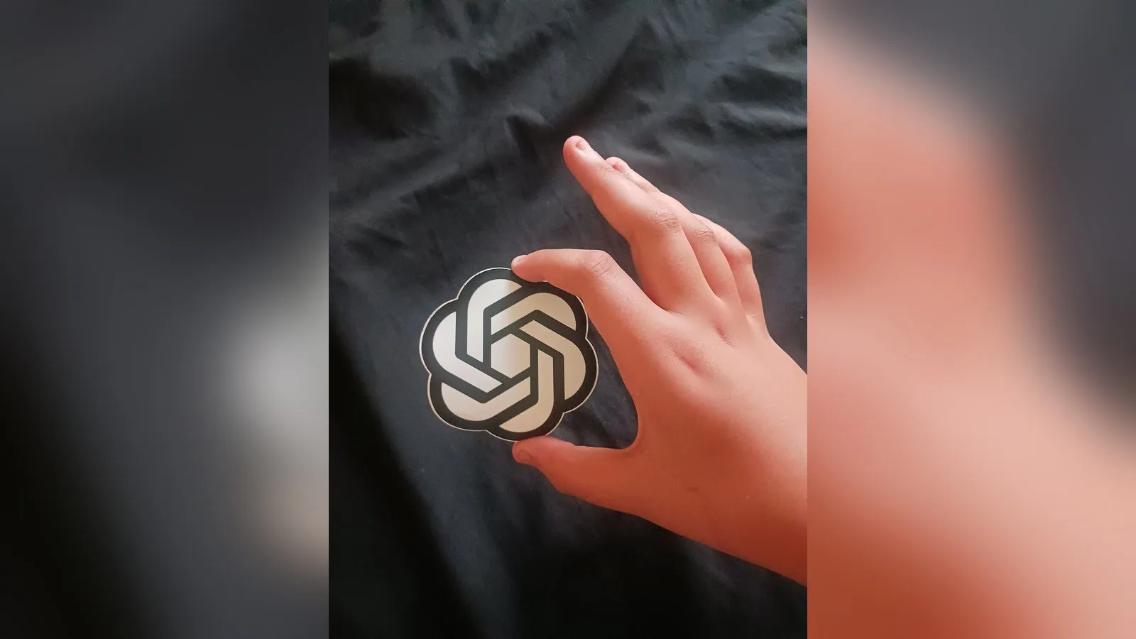 A person holding the OpenAI icon